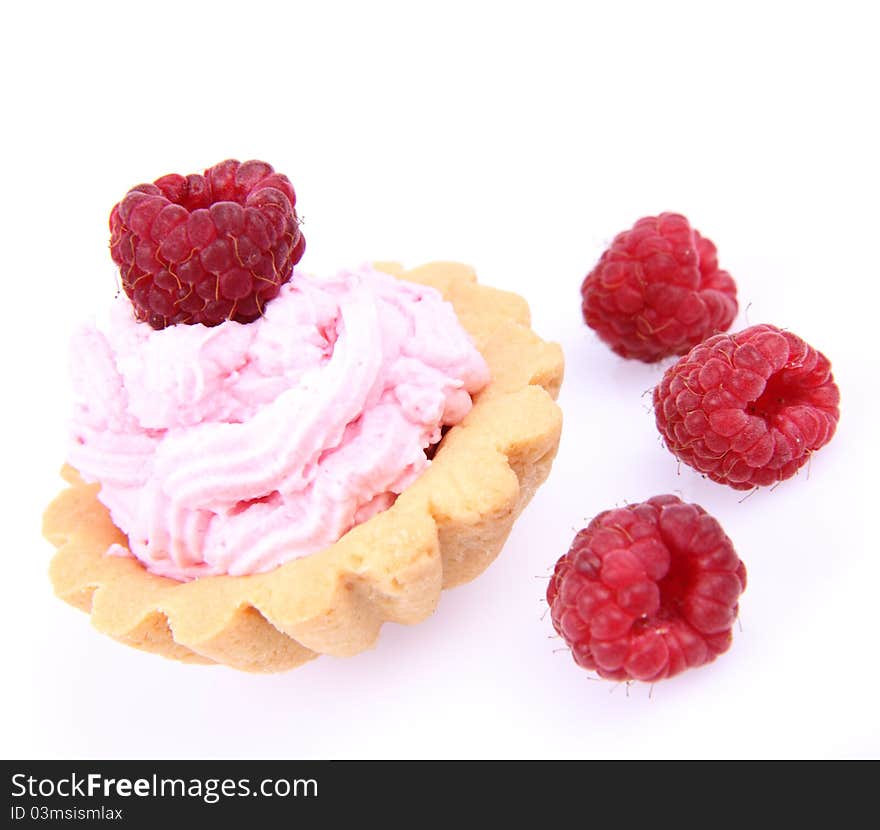 Tartlet with whipped cream and a raspberry on a white background