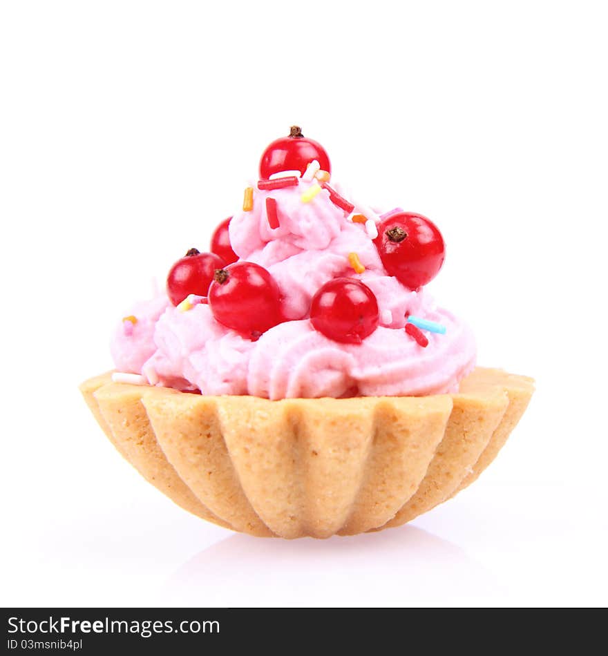 Tartlet with whipped cream, red currants and sprinkles on a white background