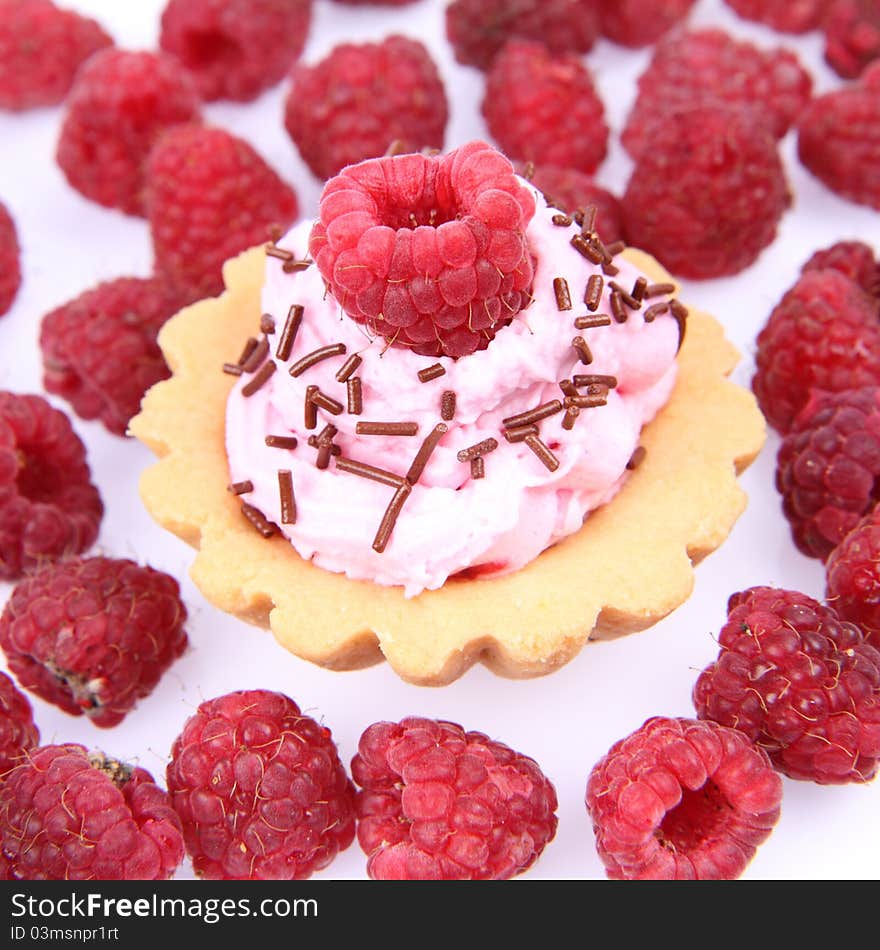 Tartlet with whipped cream and raspberries on a white background