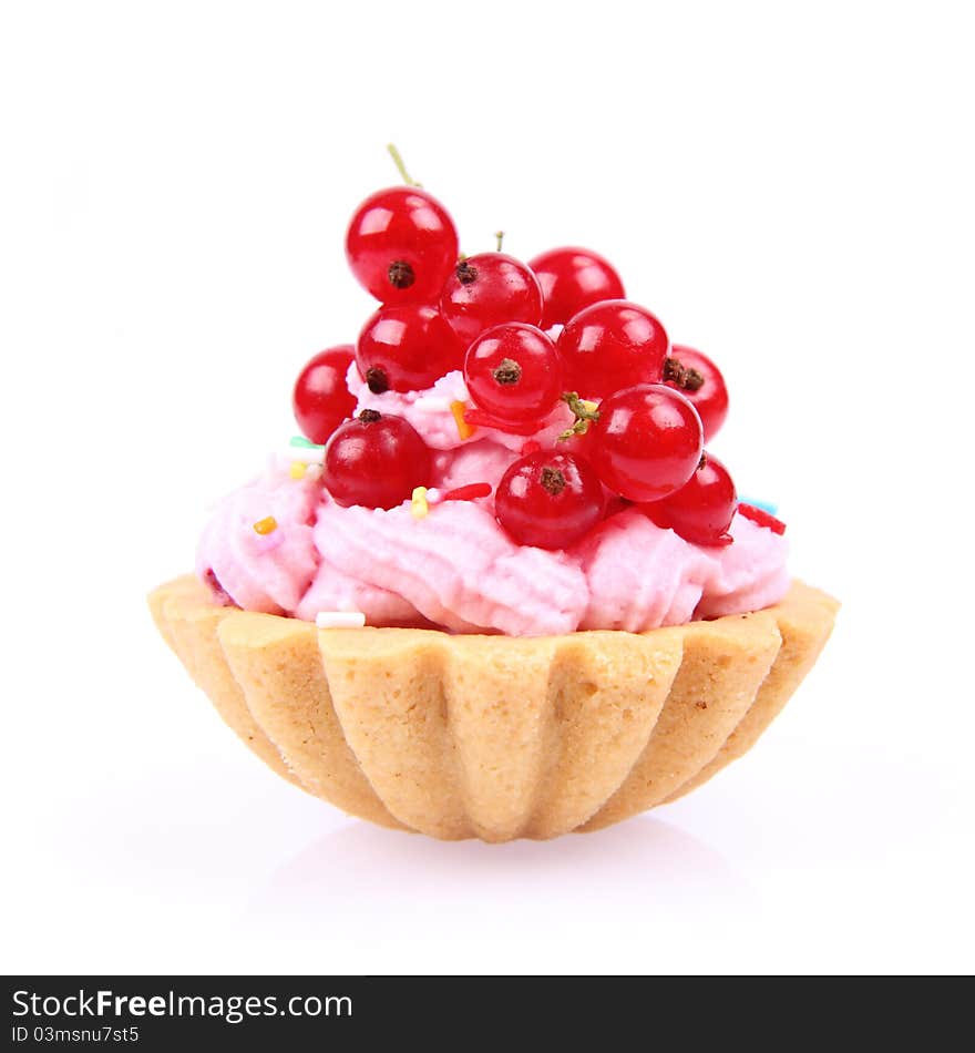 Tartlet with whipped cream, red currants and sprinkles on a white background