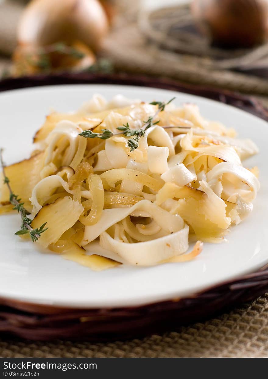 Tagliatelli pasta with onion, thyme and cheese. Selective focus