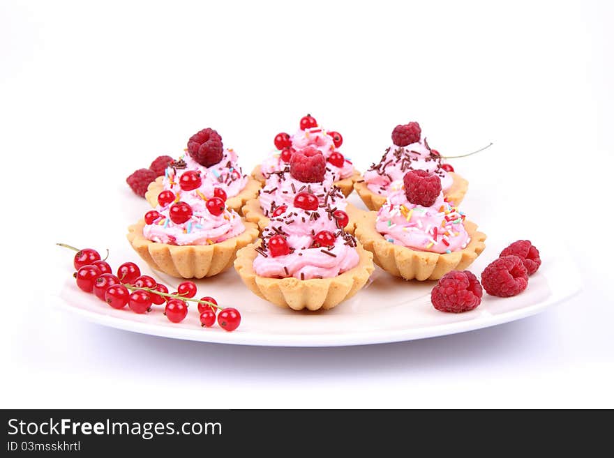 Tartlets with whipped cream, fruits and sprinkles - raspberries and redcurrants