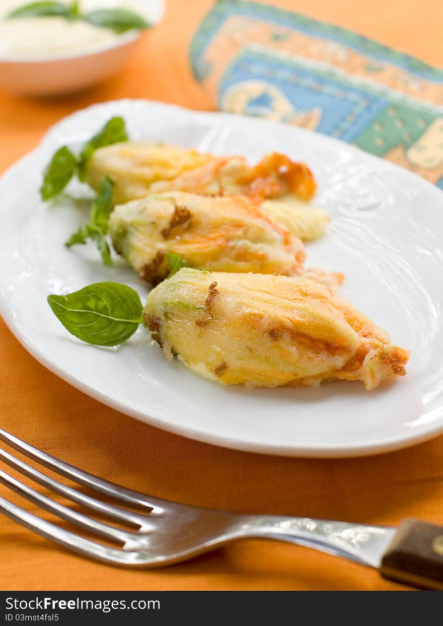 Stuffed zucchini flower on plate. Selective focus