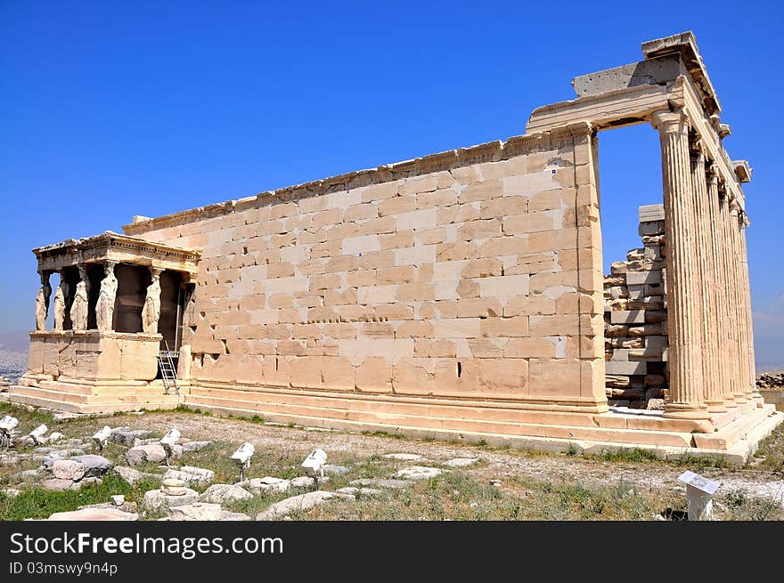 Erechtheion on blue sky background - part of Acropolis in Athens. Full view.