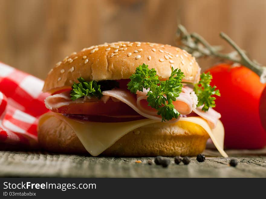 Fresh sandwich with cheese, ham and tomato on wooden table. Fresh sandwich with cheese, ham and tomato on wooden table