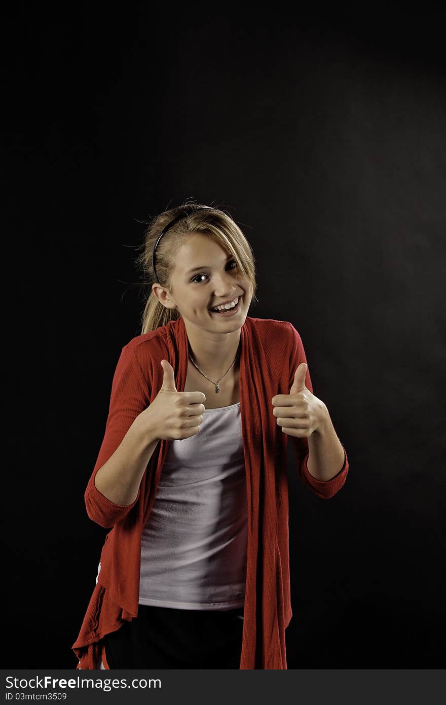 A pretty cute teenage female girl against a black background. A pretty cute teenage female girl against a black background.