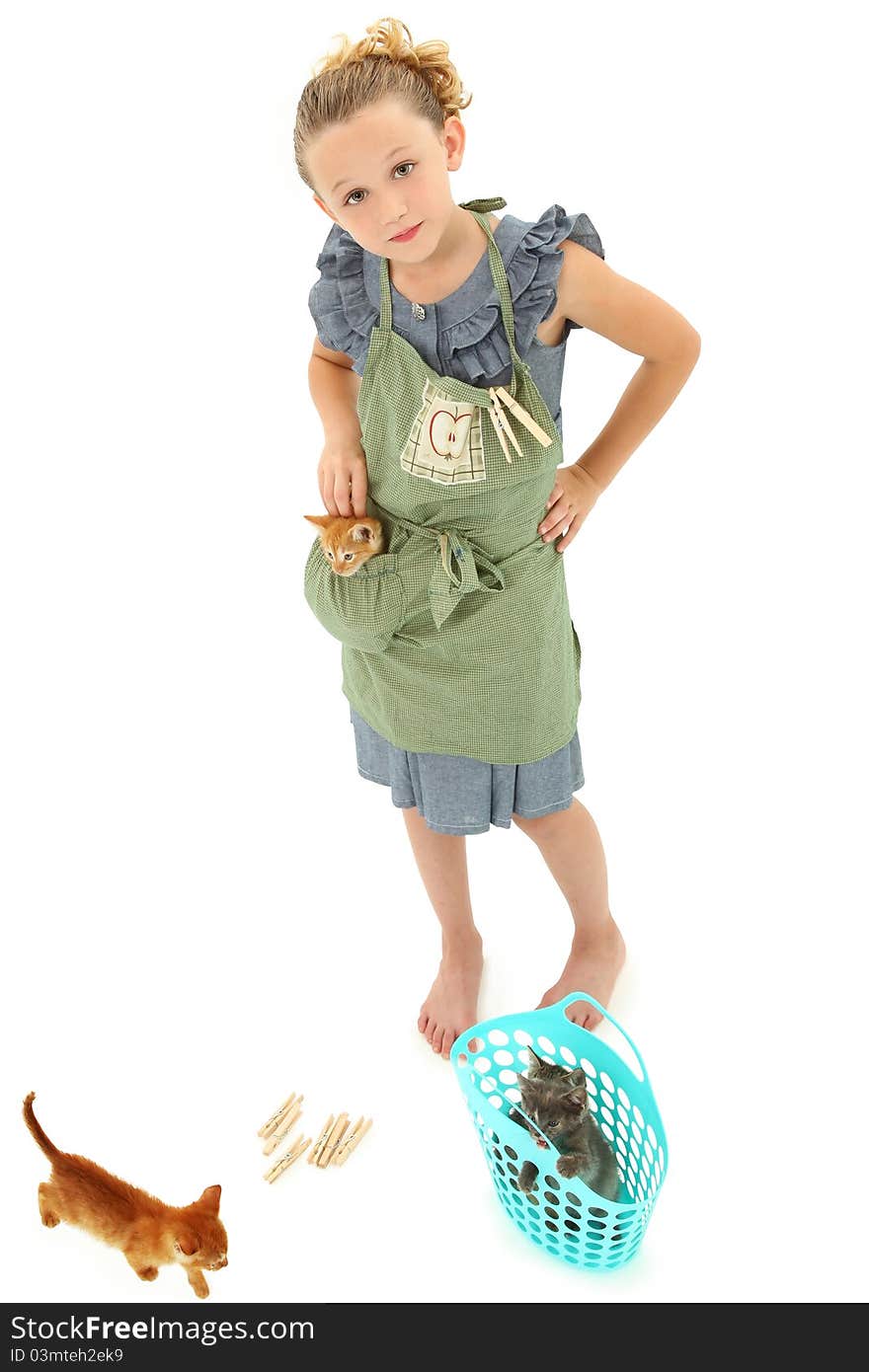 Adorable Girl Child in Apron playing house homemaker with kittens. Retro dress and apron over white background. Adorable Girl Child in Apron playing house homemaker with kittens. Retro dress and apron over white background.