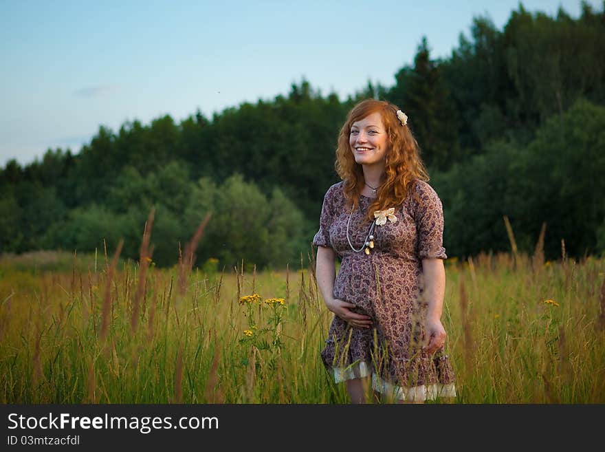 Beautiful pregnant girl on the field