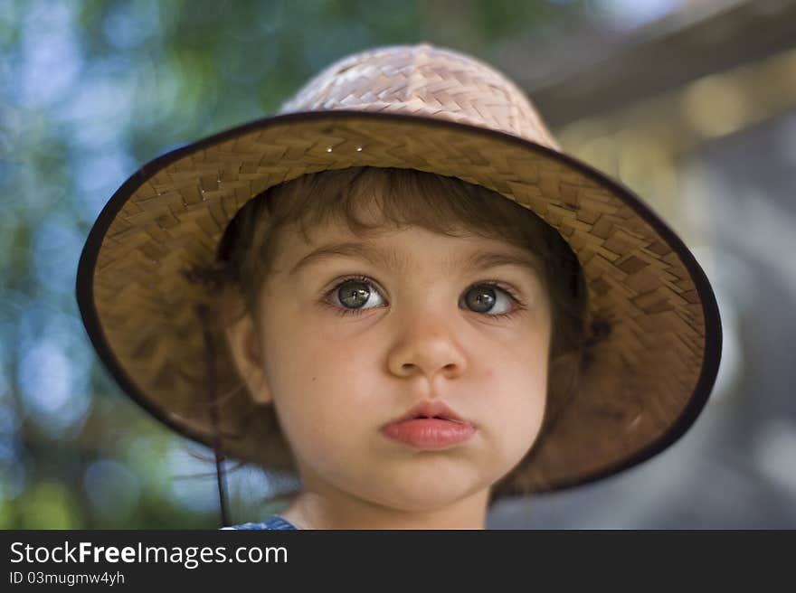 Portrait of the serious little girl with a hat, looking in a shot. Portrait of the serious little girl with a hat, looking in a shot