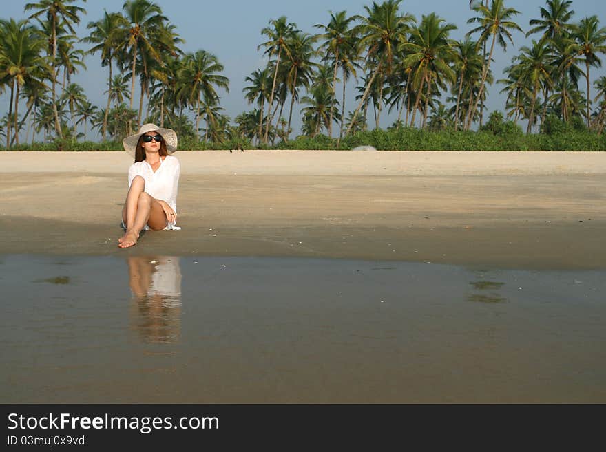 Woman in white hat lying on the beach in tropical country. Woman in white hat lying on the beach in tropical country