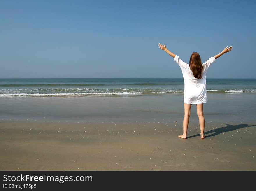 Woman on the beach near sea and blue sky