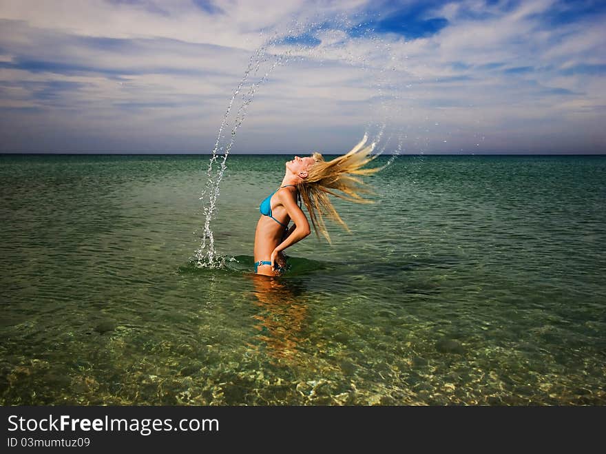 A girl splashing the sea water with her hair