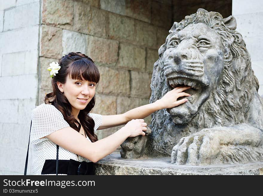 Young beautiful girl with lion statue