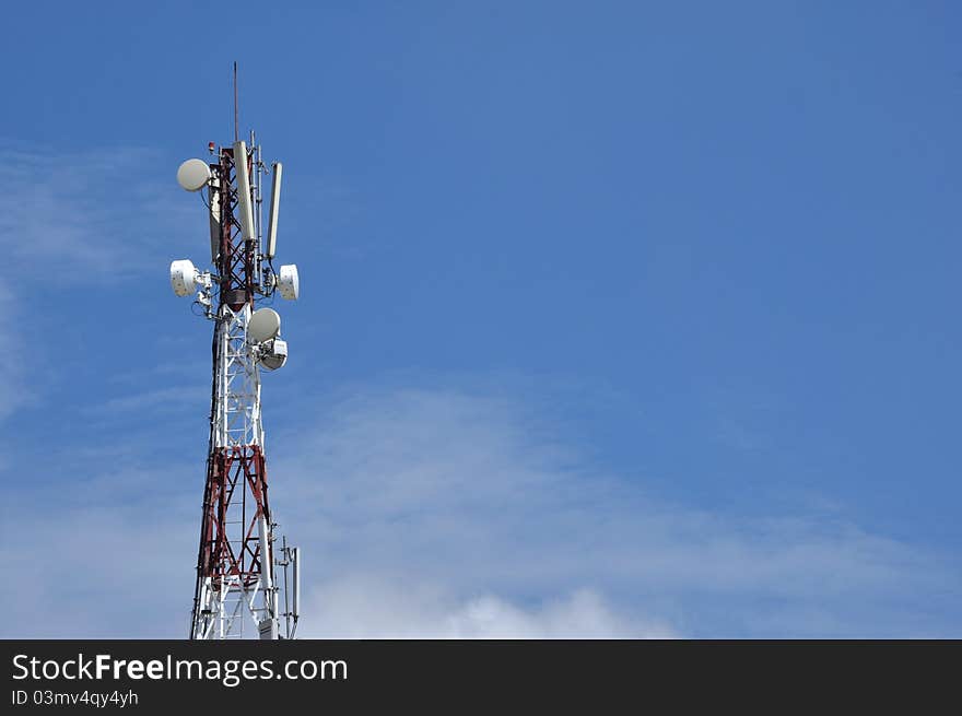 Antenna pylon transmitter and blue sky with clouds