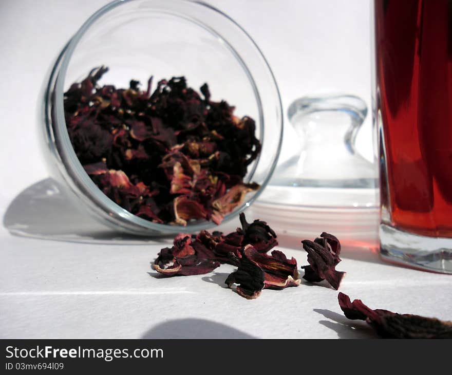 Red tea leaves in the opened jar and a glass of tea. Red tea leaves in the opened jar and a glass of tea.