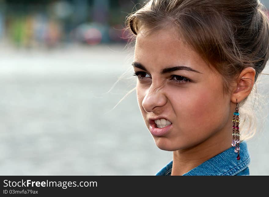 Portrait of beautiful girl in the denim vest in the square