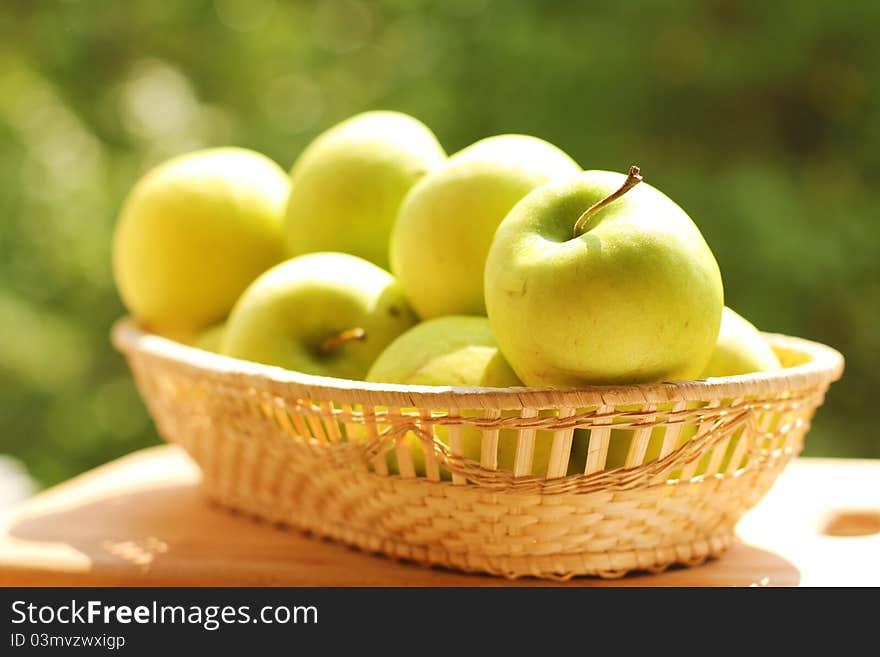 Green apples in a wicker plate