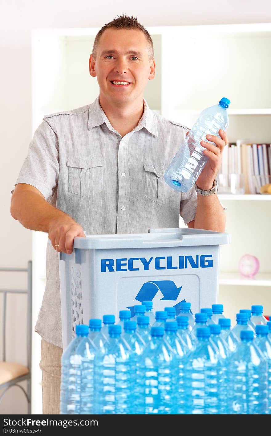 Happy man holding plastic bottle with recycling bin. Happy man holding plastic bottle with recycling bin