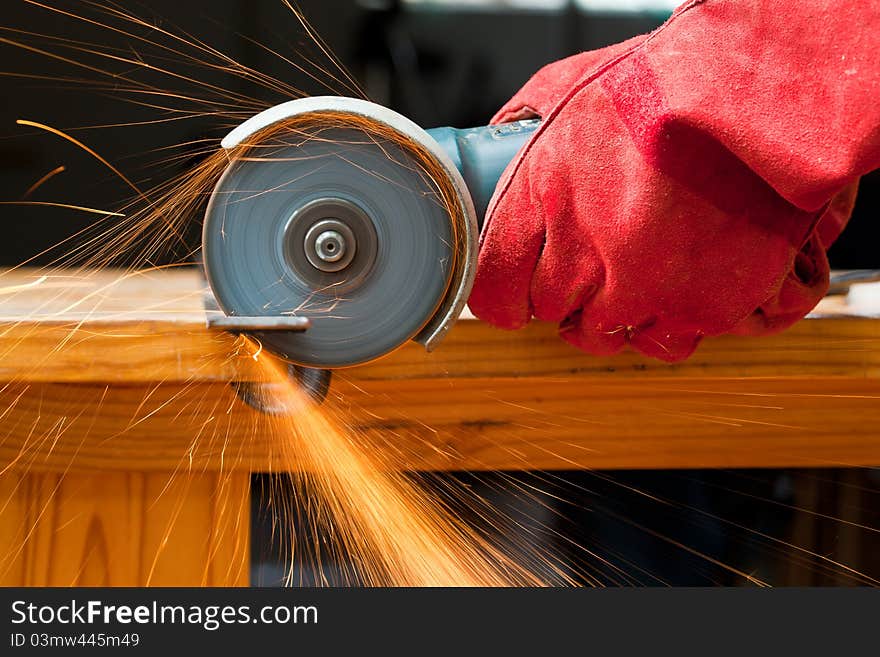 Cutting steel with a small grinder with sparks flying