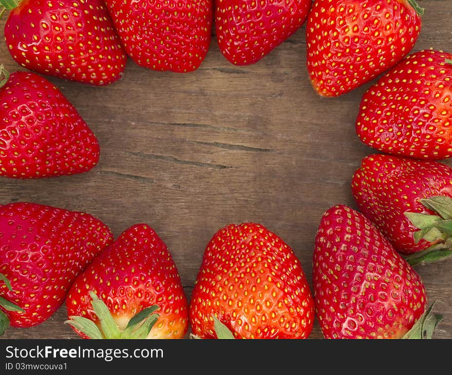 Fresh fruit making border on the wooden background. Fresh fruit making border on the wooden background