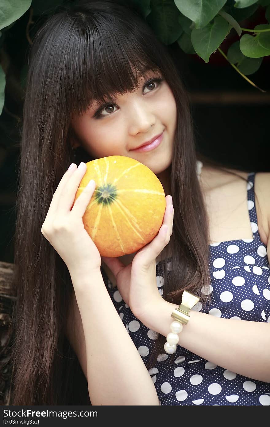 Young Chinese girl holding a melon outdoor portrait in summer. Young Chinese girl holding a melon outdoor portrait in summer.