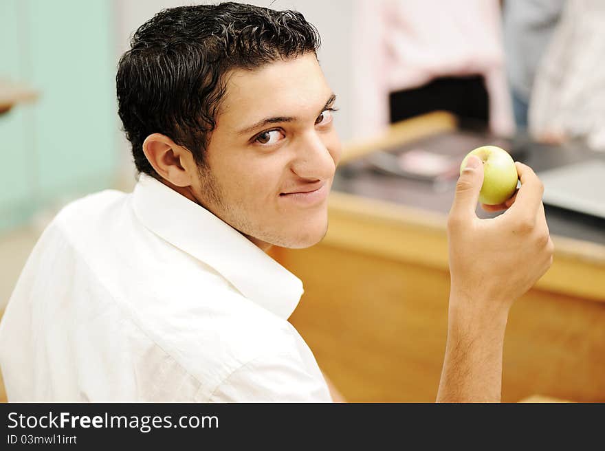 Student in collage with an apple in hand smiling