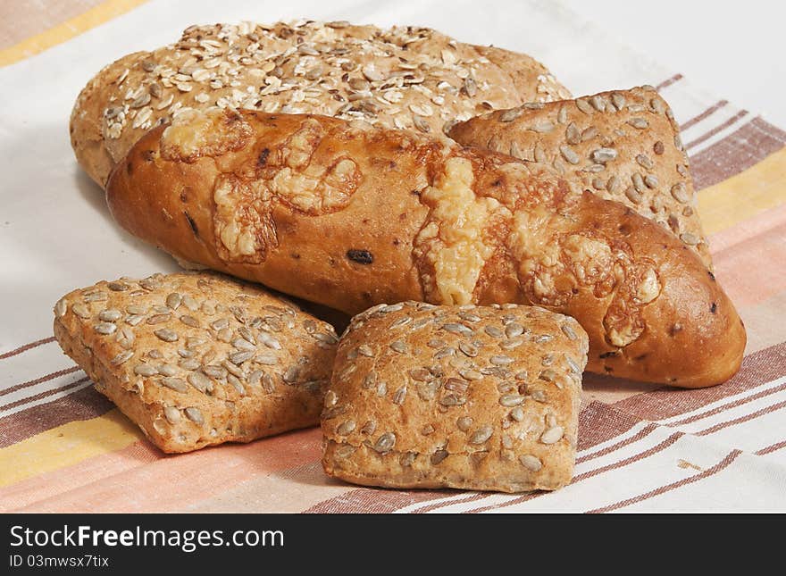 Onions long loaf, rolls for sandwiches and grain bread on a linen towel