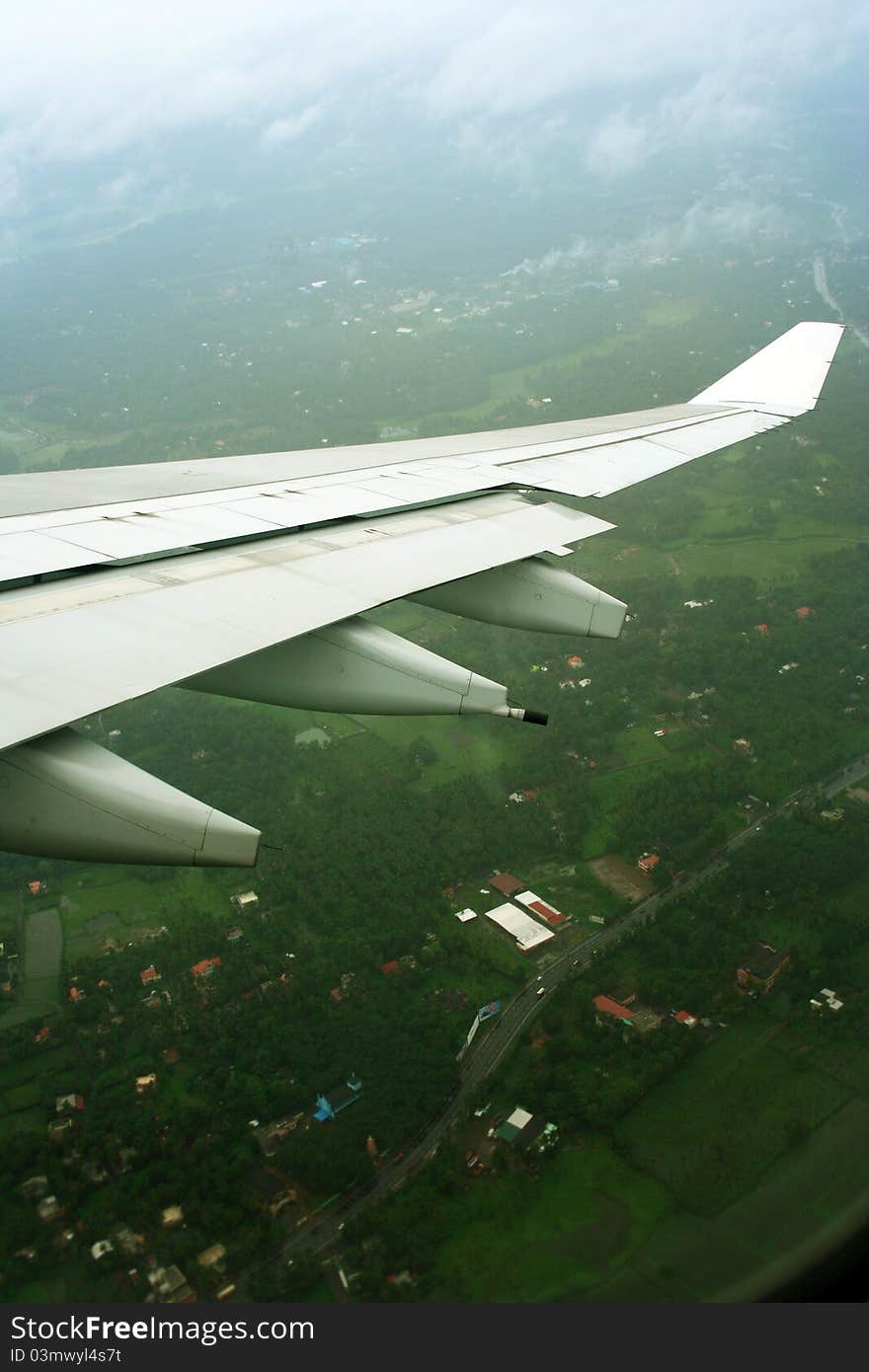 Aeroplane wings over green landscape