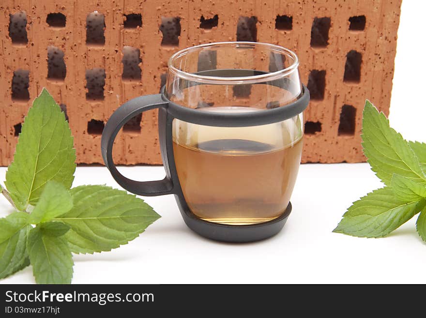 Peppermint tea with mint in front of brick