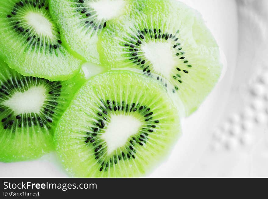 Fresh, healthy kiwi slices presented on a white plate.