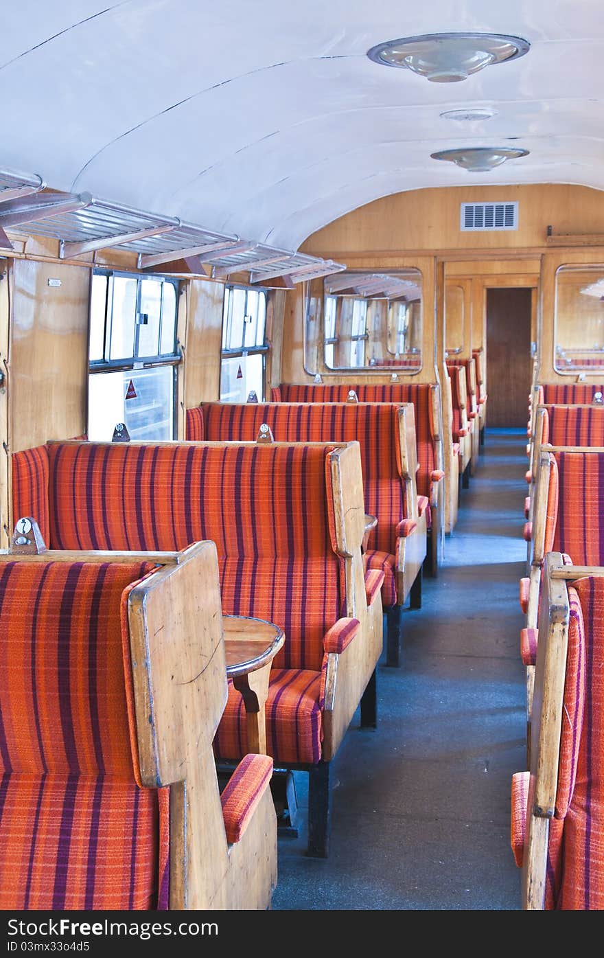 Old railway carriage in red striped seats