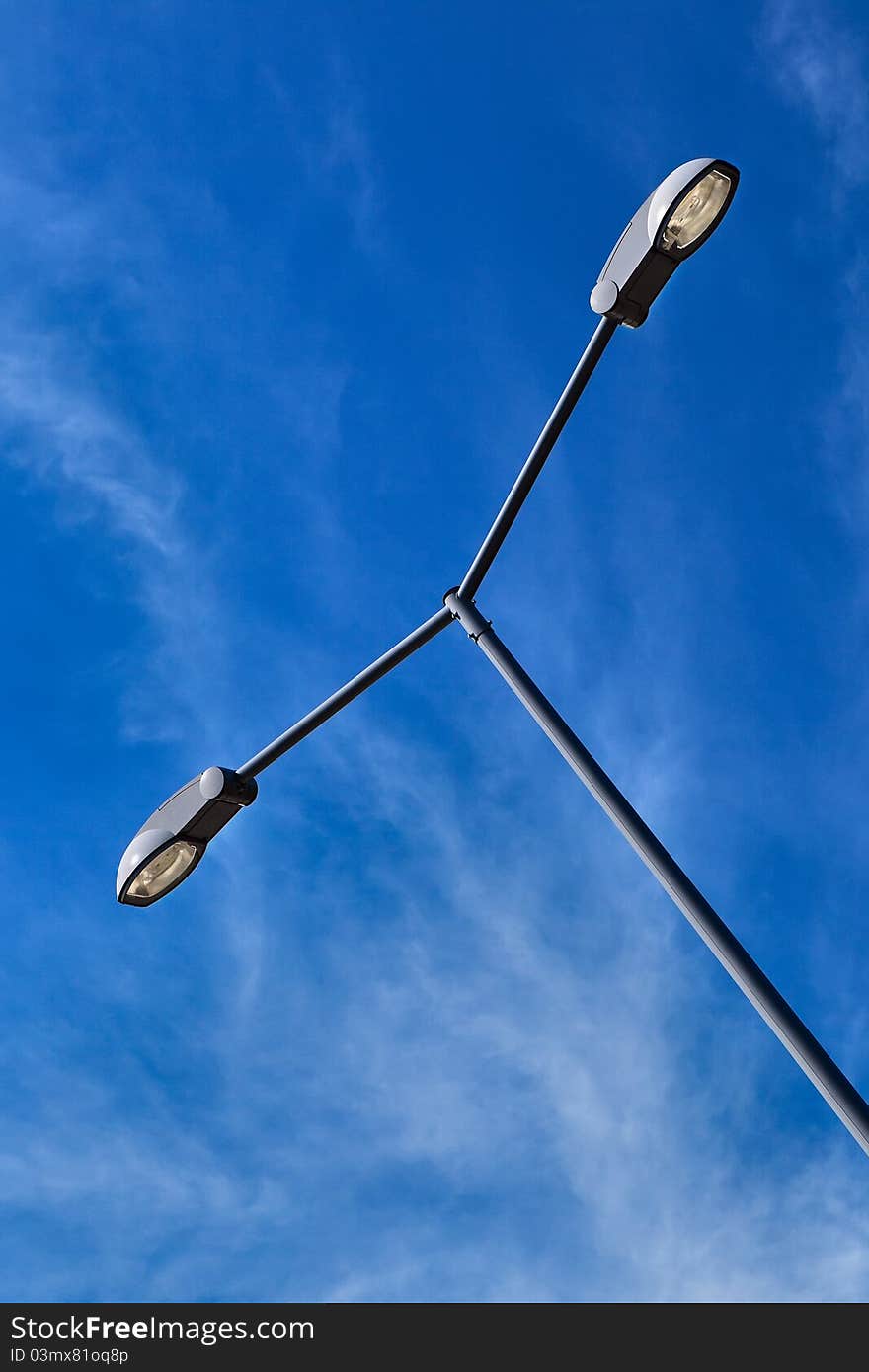 Modern electric street light pole over blue sky with clouds. Modern electric street light pole over blue sky with clouds.