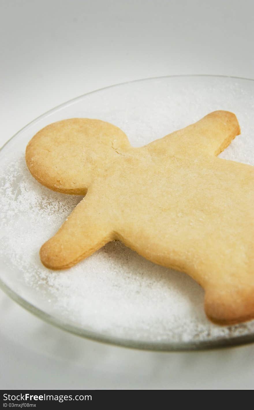 Christmas cookie shaped as gingerbread man on glass plate