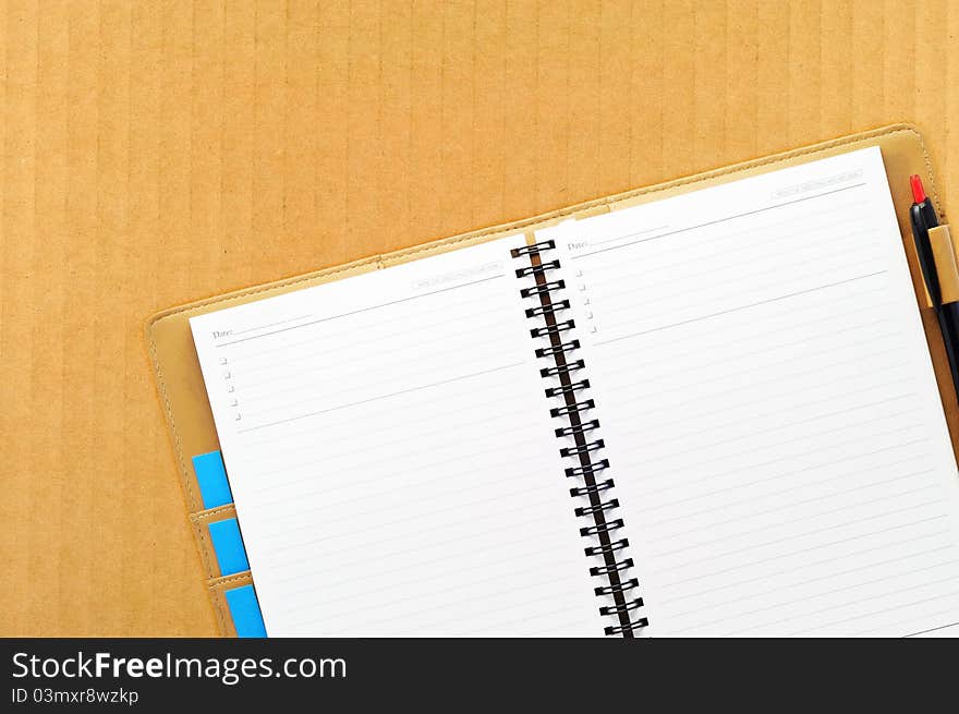 Open blank note book, on cardboard background. Open blank note book, on cardboard background