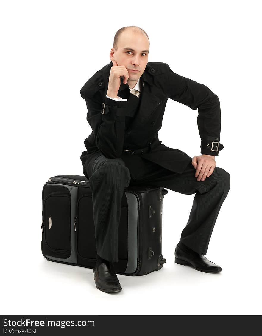 Businessman sitting on his luggage isolated on white