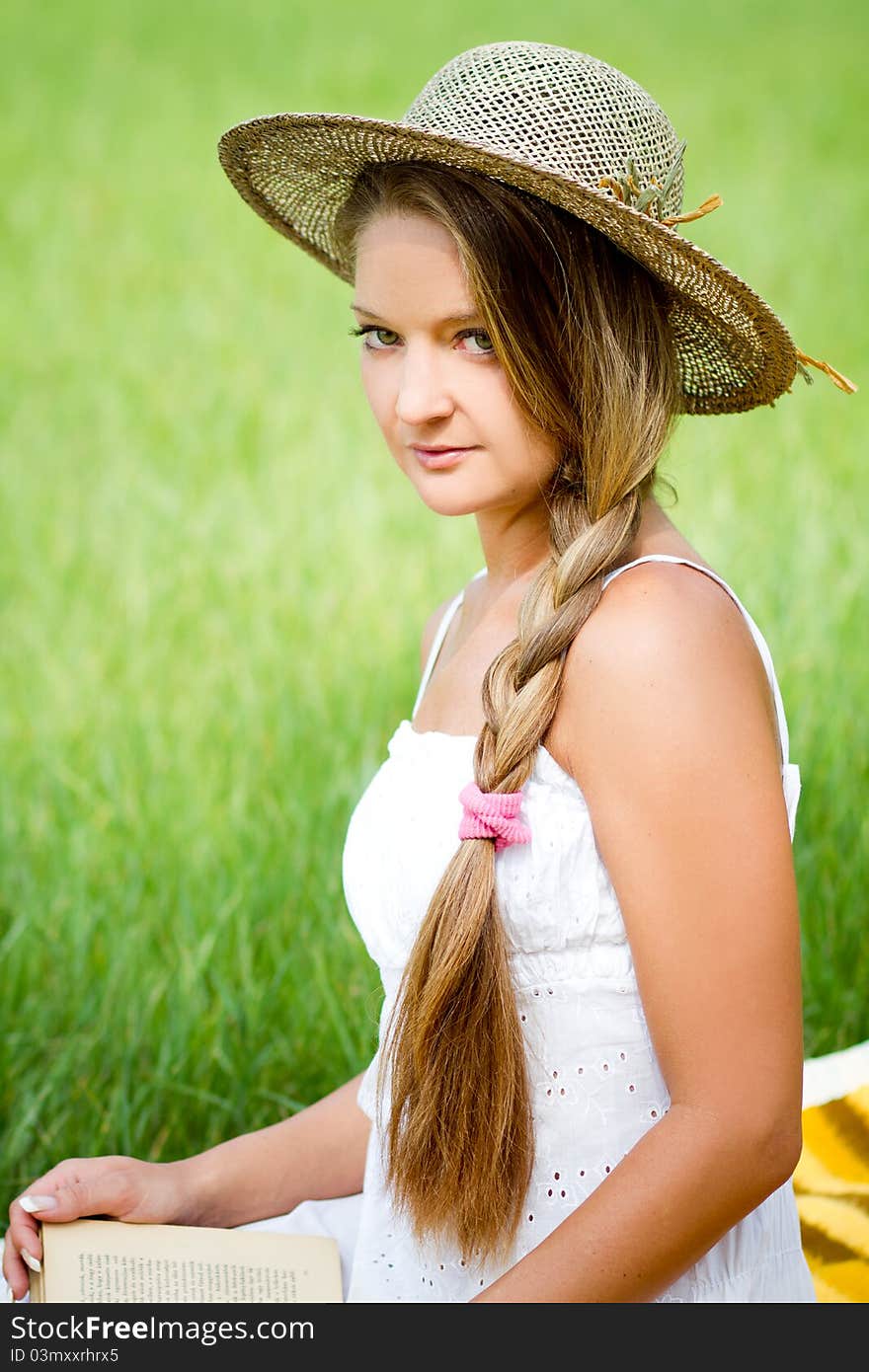 Young beautiful girl with book in nature in hat. Young beautiful girl with book in nature in hat