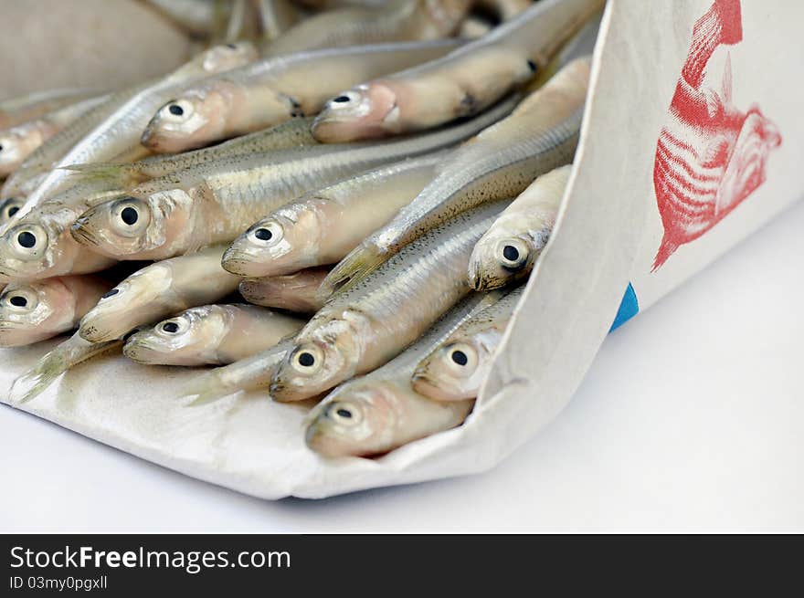 Fresh little anchovies in a paper bag. Fresh little anchovies in a paper bag