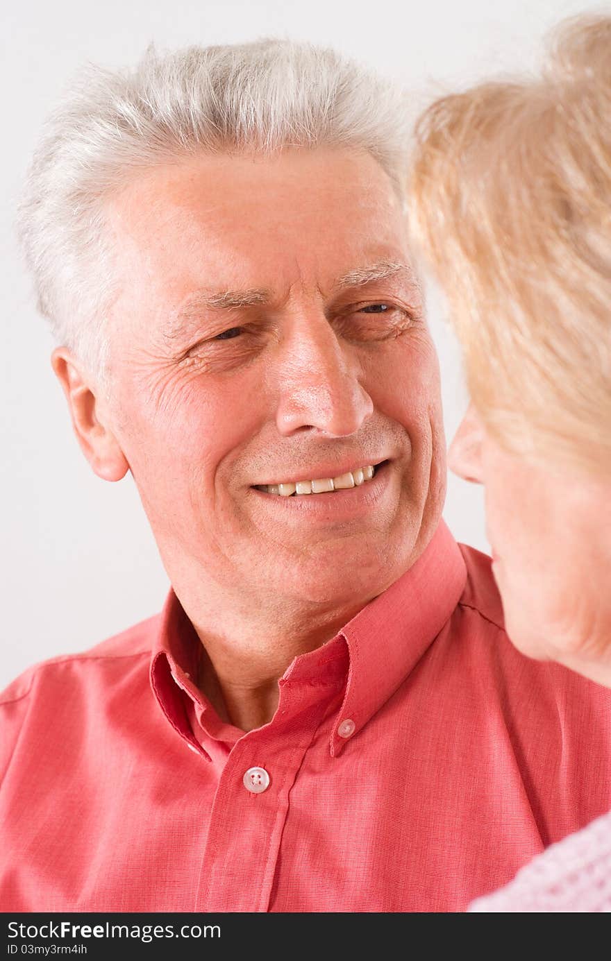 Cute elderly couple smiling on a white