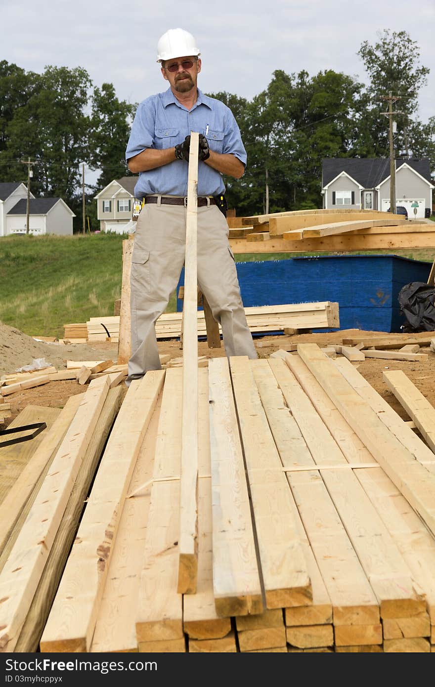 Carpenter inspecting wood before selecting the next support beam