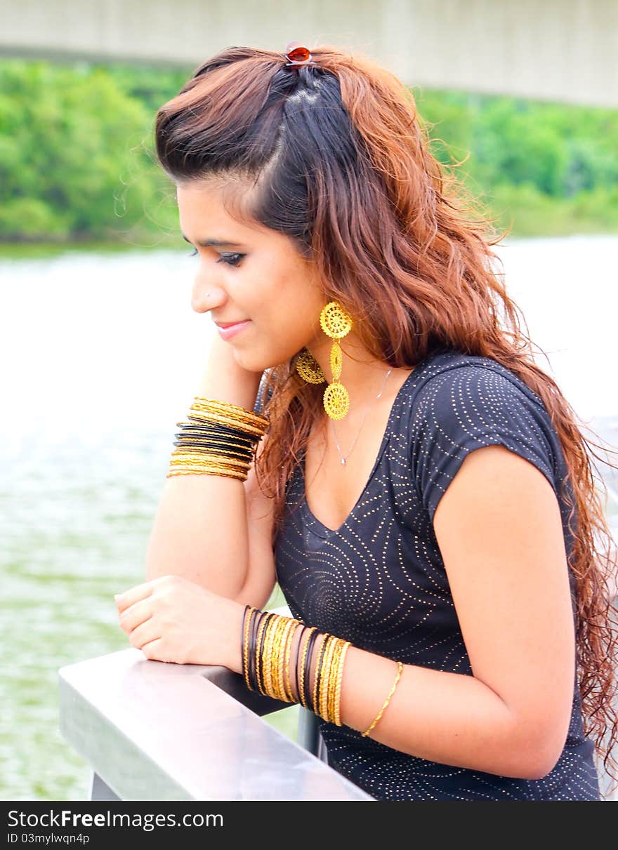 Beautiful Pakistani model posing outdoors with gold jewels. Beautiful Pakistani model posing outdoors with gold jewels