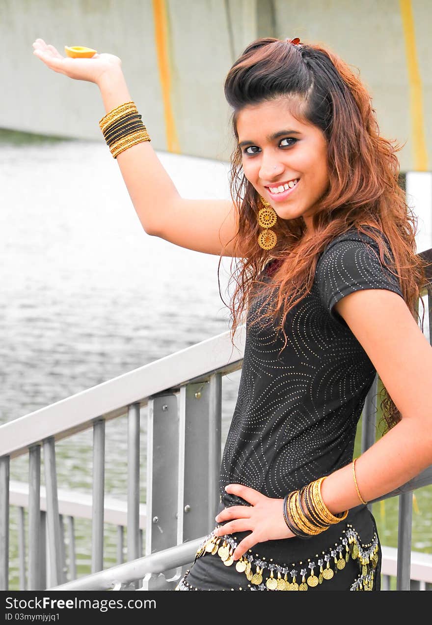 A young and modern Pakistani model holding a traditional indian lamp in her hands and posing. A young and modern Pakistani model holding a traditional indian lamp in her hands and posing