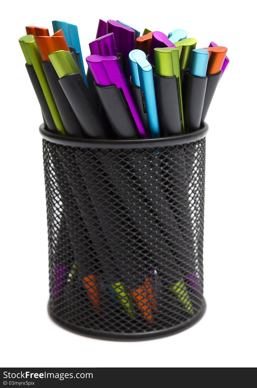 Ballpoint pens in pencil holders on white