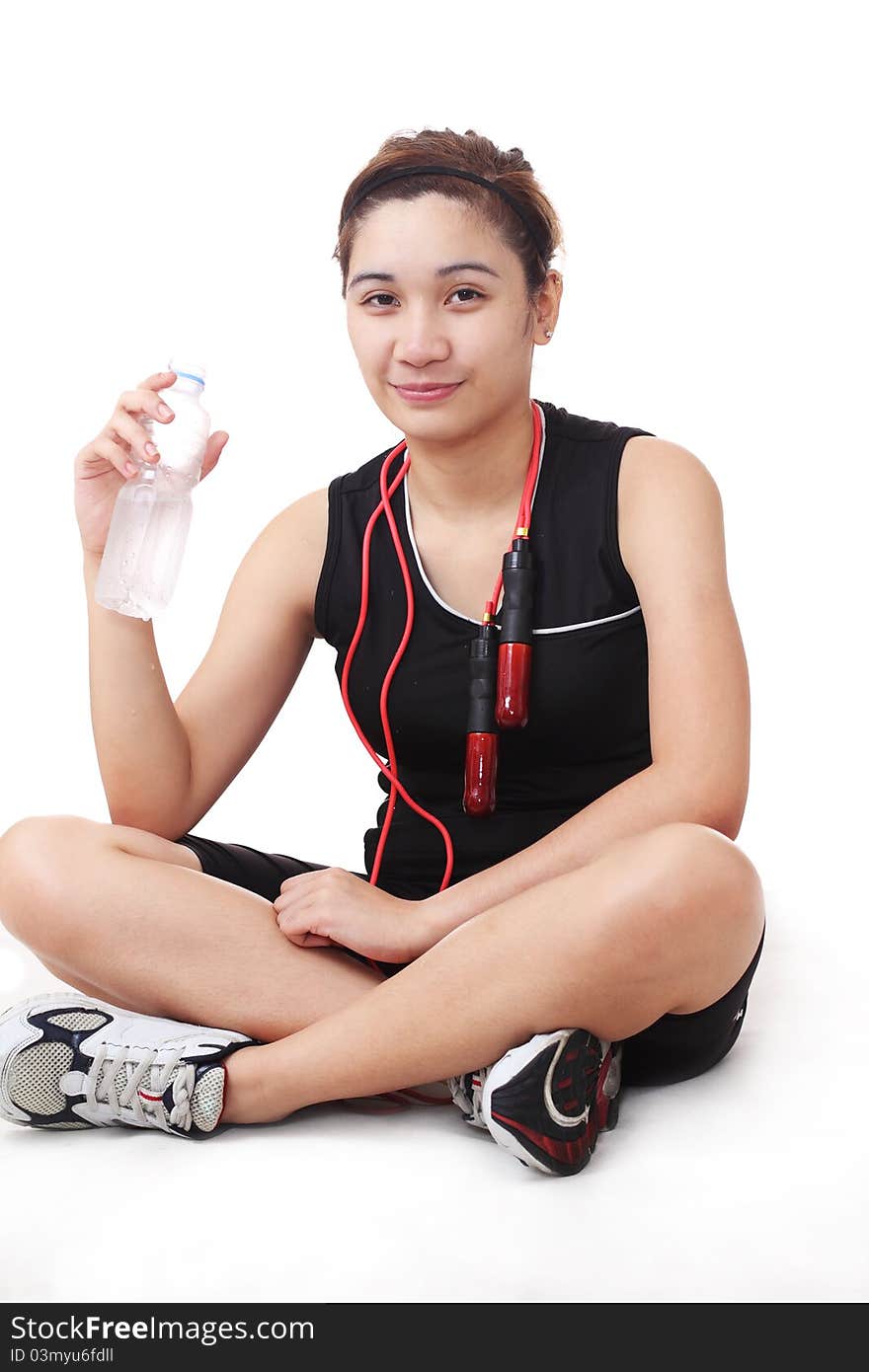 Lady athlete holding a bottled water while resting