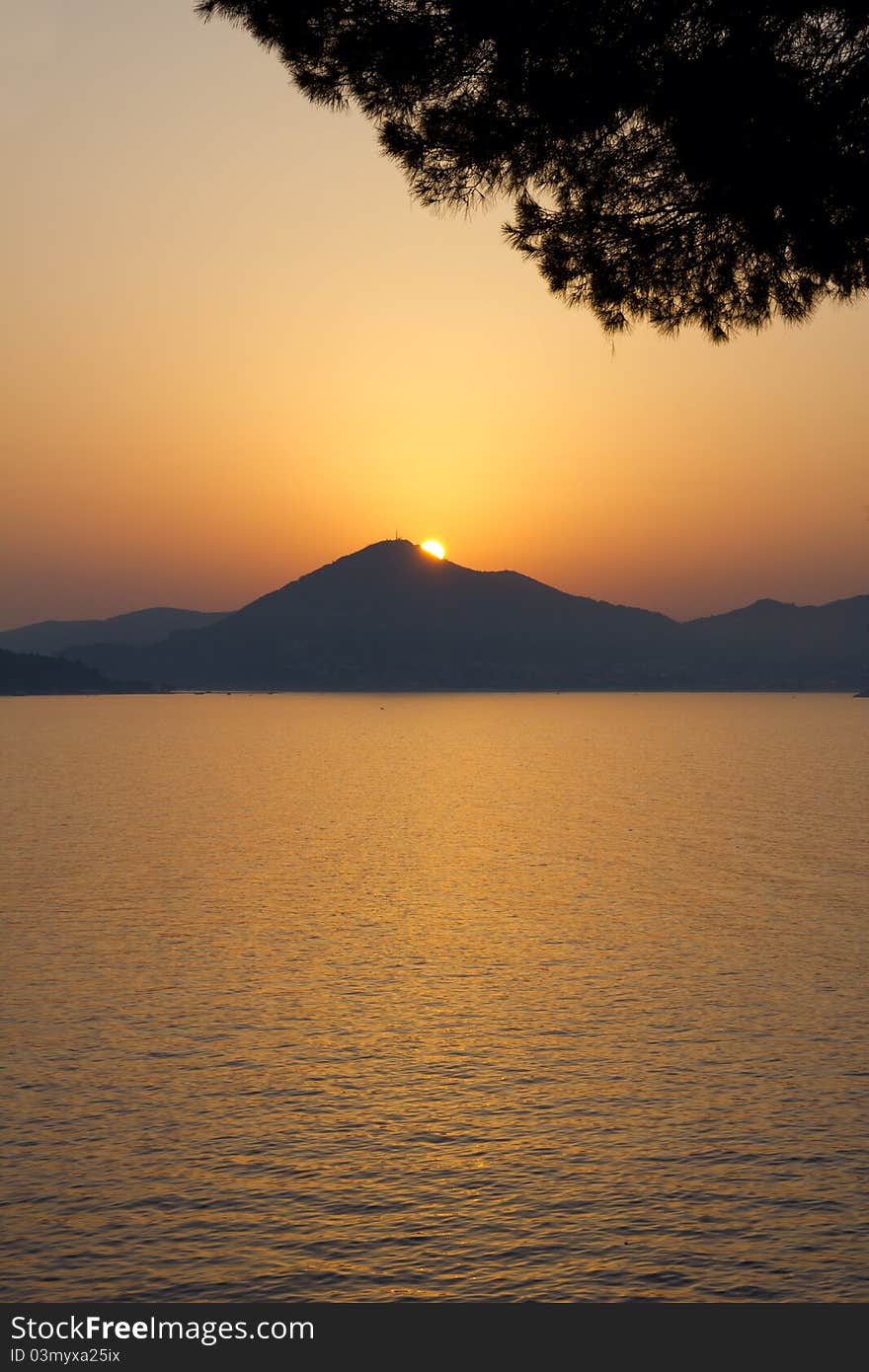 Very beautiful sunset above a sea. A sun sits down for a mountain