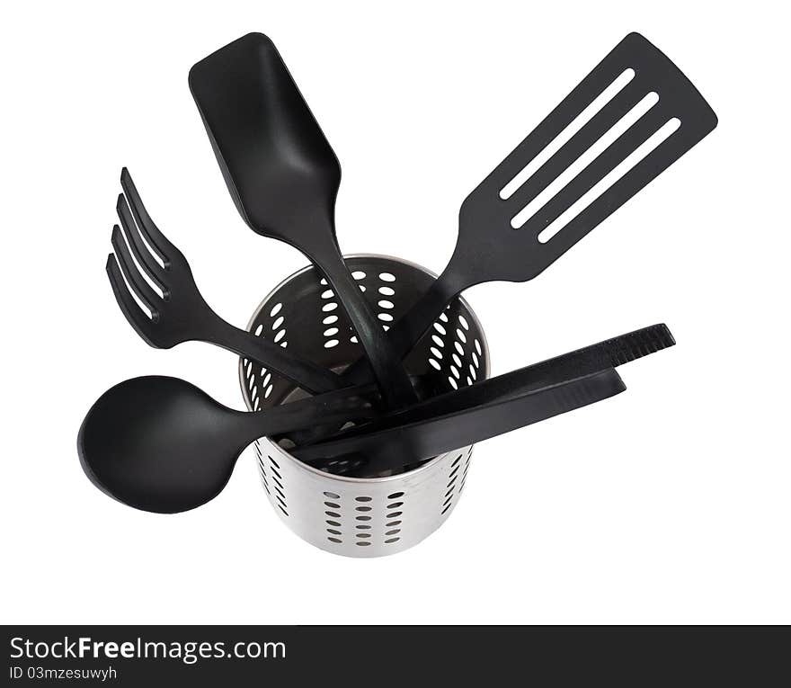 Kitchen utensils in a utensil holder isolated against a white background