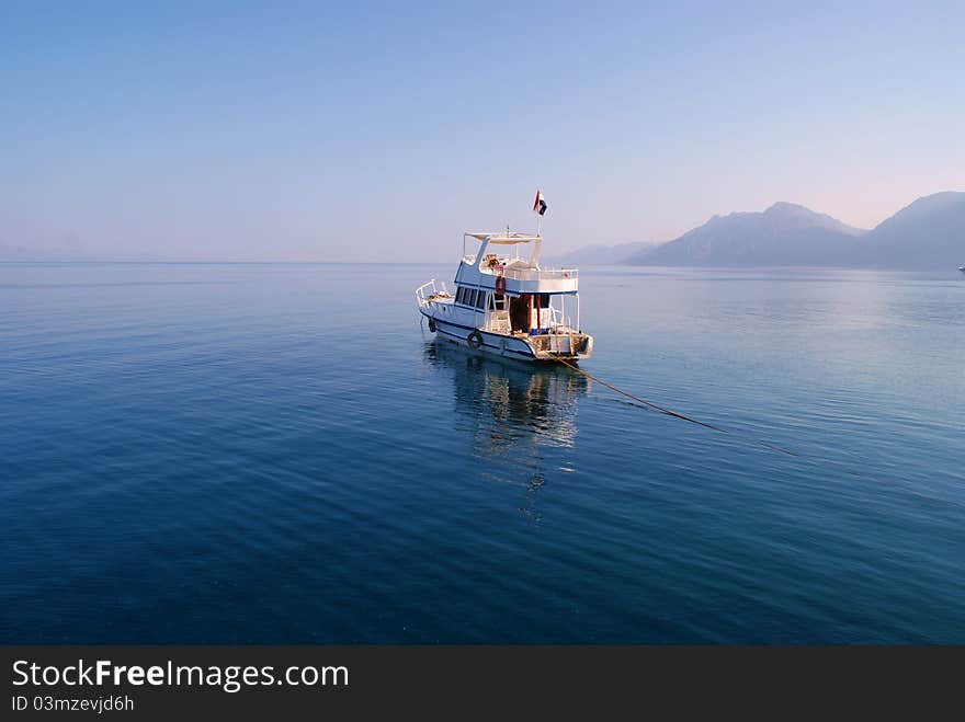 Boat on incredibly calm sea with mountains in the distance. Boat on incredibly calm sea with mountains in the distance