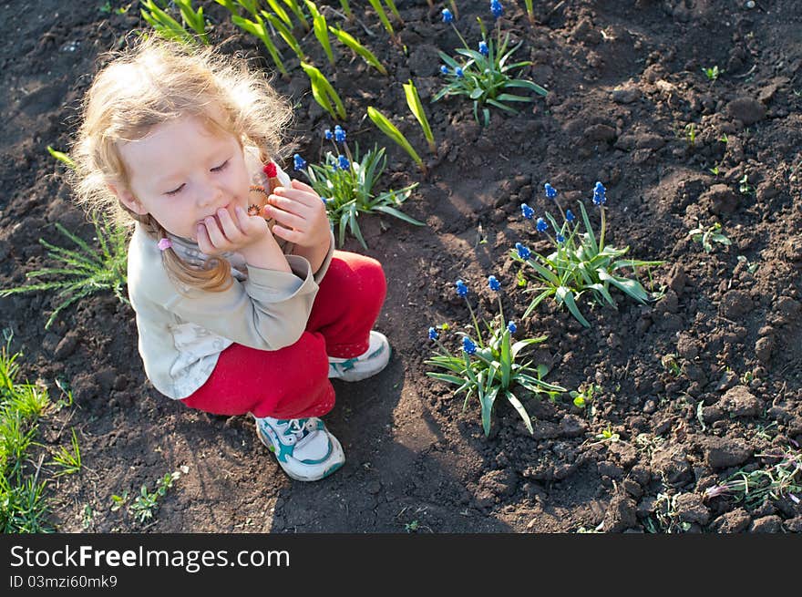 Little girl sitting on a bed of flowers