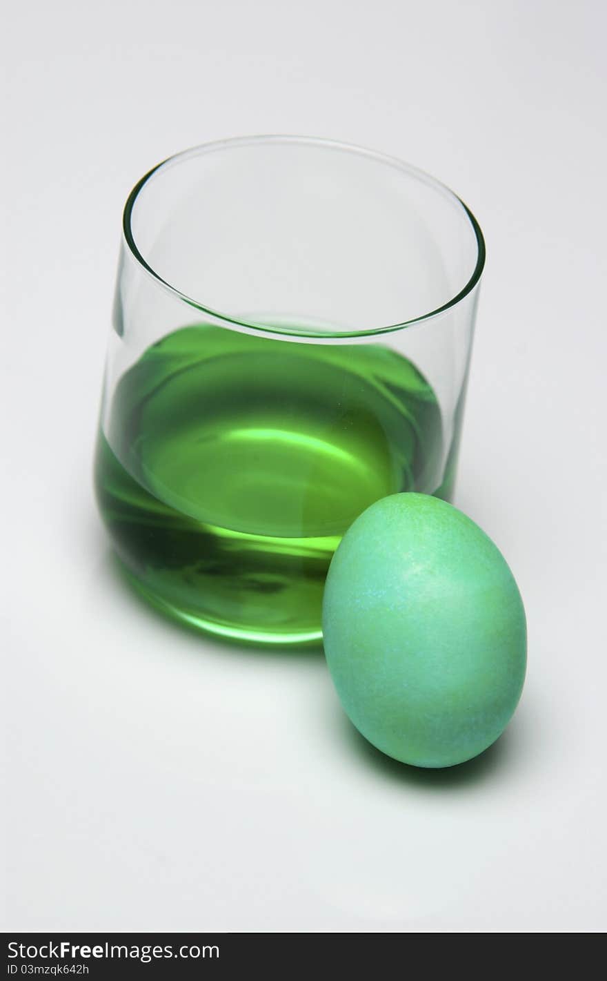 Glass of green dye and Easter egg. Glass of green dye and Easter egg