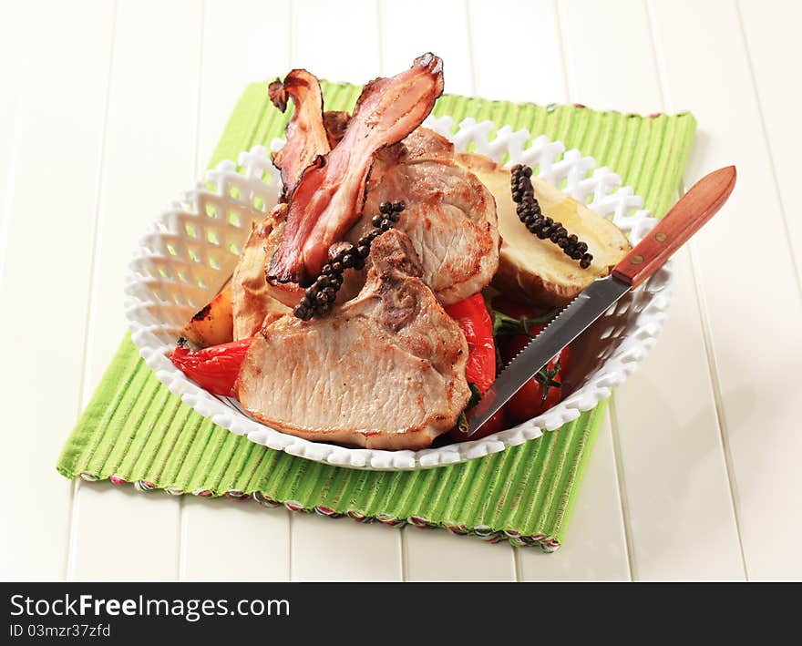 Juicy pork chops and bacon with potato and red peppers. Juicy pork chops and bacon with potato and red peppers