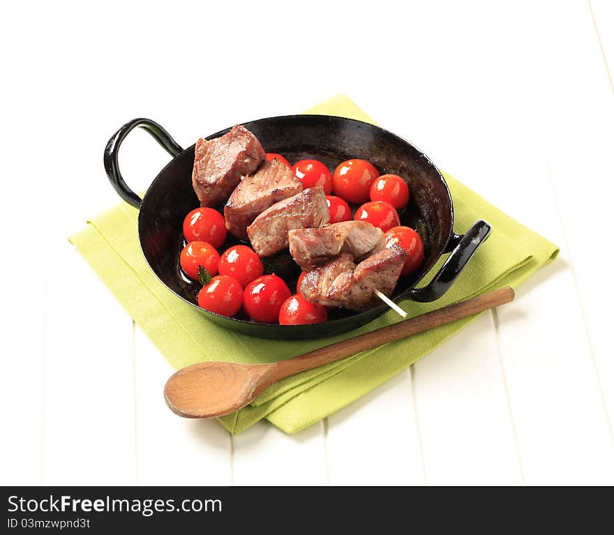 Pork kebab and cherry tomatoes in a pan. Pork kebab and cherry tomatoes in a pan